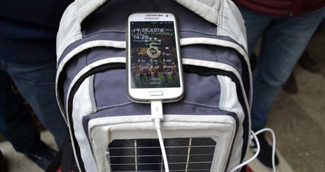 Sırt çantasındaki güneş paneliyle telefon şarjı